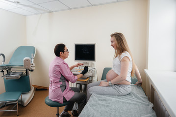 A pregnant girl is advised by a doctor after an ultrasound in the clinic. Medical examination