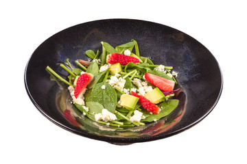 Gourmet Strawberry salad with avocado, cheese, and arugula on a black plate, isolated on white background