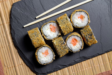 Sushi roll tempura with prawns on the mats background. Top view of sushi . Sushi food photo for menu.