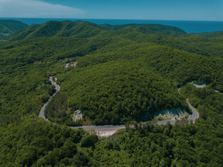 Mountain winding zig zag road. Top aerial view: cars driving on road from above.