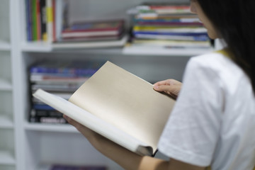 Asian students girl reading blank pages of book in library