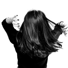 Fototapeta premium Black and white brunette girl holding her black hair isolated on white background. Portrait of beauty girl.