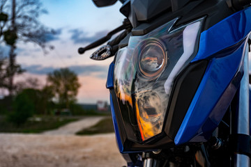 Front view of Motorcycle headlight sport bike with sunset reflecting