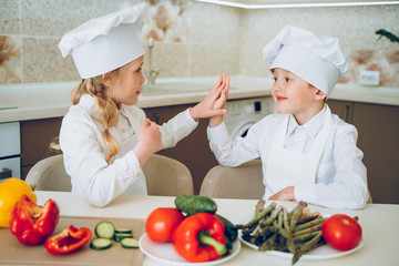 little cooks cut vegetables for salad