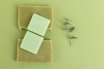 Natural soap and  eucalyptus on green background. Self-care. Green monochrome. Minimalism