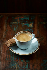 Cup of coffee with cantuccini (Italian cookies) on rustic wooden background.