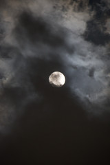 Naklejka na ściany i meble Luna llena entre nubes del anochecer