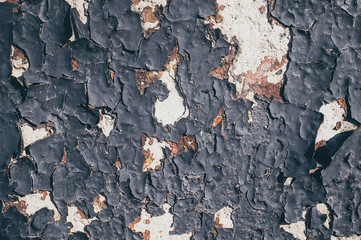 Peeling old black paint and concrete wall. Grunge background