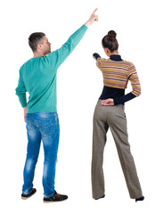 Obraz premium Back view of couple in sweater with mobile phone.