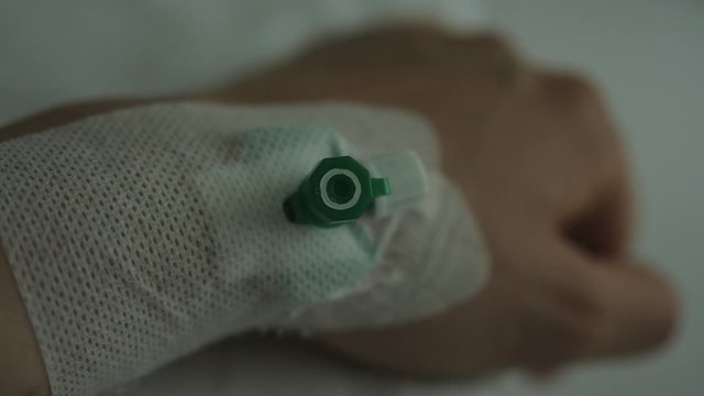 patient hospital hand with needle and venflon inserted dark mood sad sadness