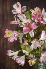 Bouquet from Alstremeria, gently pink flowers of Peruvian lily. Flowers for the holiday, brown wooden background