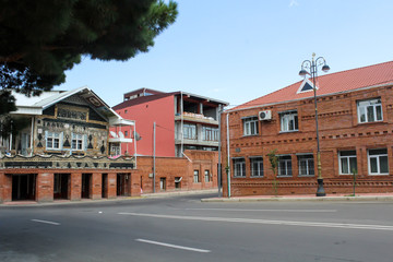 Red brick house and a city planted with green trees