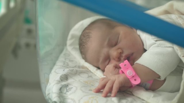 newborn baby lies in a hospital cot wheelchair bed crib sleep sleeping sleeps