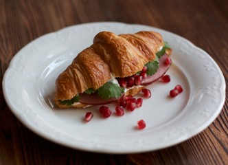 Ham croissant with pink sauce and pomegranate