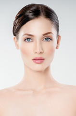 Obraz premium Beautiful face of young adult woman with clean fresh skin. Looking at Camera.