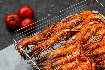 cooked large shrimps langoustines lie into the grille close up gray background