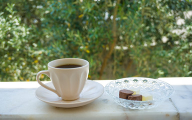 Turkish Coffee with sweet cookies and delights on nature background. Low view composition. Closeup shot of hot Greek Coffee. Beautiful tasty traditional drink of Turkish culture. Enjoy concept photo