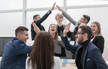 group of young business people giving each other a high five