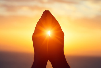 silhouette of male  raising hands praying for God's blessings at sunset or sunrise light,...