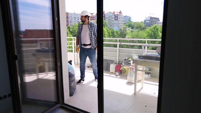 repairman inspecting an apartment with balcony during renovation
