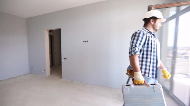 repairman walks in the apartment during the construction