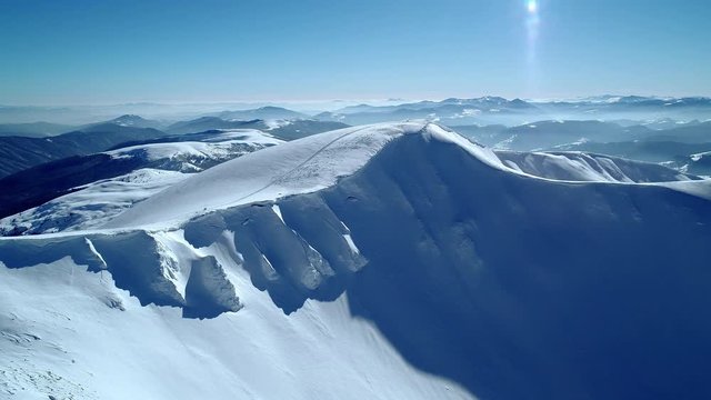 Bewitching view of the majestic snowdrifts located in the mountains on a sunny cloudless winter day. The concept of beautiful northern nature and wonders of the world.