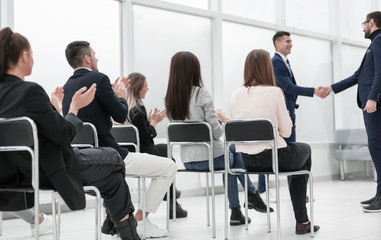group of young people sitting on chairs in the conference room