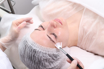 Obraz na płótnie Canvas The woman on reception at the beautician. Cosmetic procedures for the face and neck. The concept of skin care face and neck