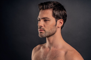 Fototapeta premium Handsome young bearded man isolated. Portrait of shirtless muscular man is standing on grey background. Men care concept.