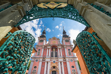 The opened magnificent openwork metal entry gate and beautiful facade of baroque Basilica of the Visitation of the Blessed Virgin Mary in Swieta Lipka village, in Masuria, Poland