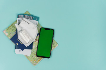 Immigration passport of citizen ID card with air tickets and face mask respirator and antiseptic and phone and maps. pandemic journey