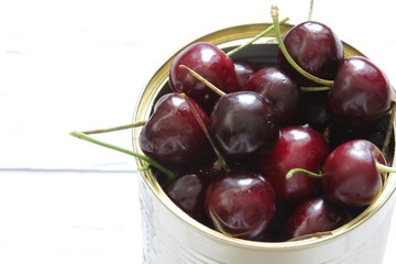 Fresh red cherry berries in a tin can on a white background. Healthy food.