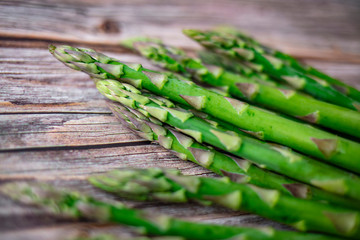 Asparagus on rustic wooden background. Fresh green asparagus on wooden background overhead shoot. Healthy food concept. Top view. Copy space.