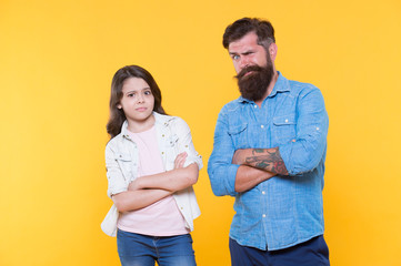 Oh, please no. Man and child yellow background. Bearded man and little girl keep arms crosses. Hipster man and small kid in casual style. Father and daughter relationship. Fatherhood changes man