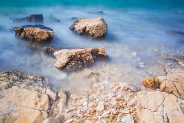 Rocks and waves at a pebble beach near Novalja town on Pag island in Croatia