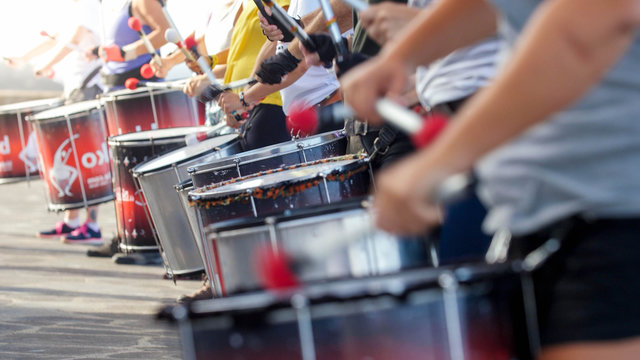 Closeup photo of of street artists playing on drums on the city street during festival or carnaval