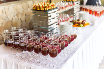 on a wooden table in the wedding banquet area are snacks, fruits, sweet cakes and muffins and lemonade drink