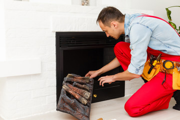 repairman repairs and installs a fireplace in the apartment