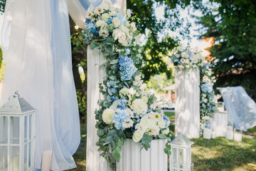 the wedding ceremony is decorated with flower arrangements and candle stands in a country complex