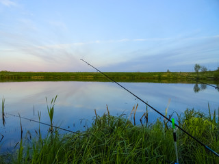 Fishing on a pond with fishing rods. Beautiful pond and fishing rods on the background of the pond.