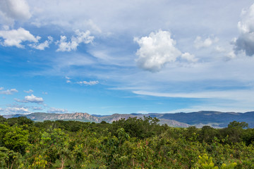Fototapeta na wymiar Cerrado e montanhas com o céu azul e nuvens brancas.
