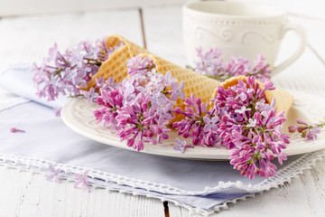 View purple lilacs. Shallow depth of field with lilacs and lilac leaves on wooden table