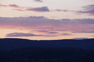 Beautiful colorful sky after sunset over mountains.
