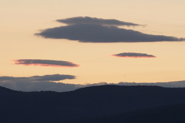Beautiful colorful sky after sunset over mountains.