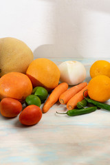Table with fruits and vegetables on white background