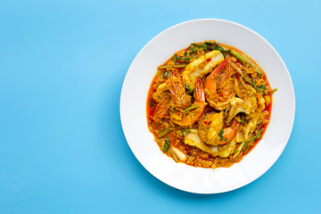 Fried seafood with curry powder on blue background