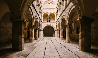 Fototapeta na wymiar The interior of the Sponza Palace in Dubrovnik, Croatia. Courtyard with columns and open-air arches.