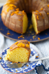 Orange bundt cake on a blue ceramic and striped napkin