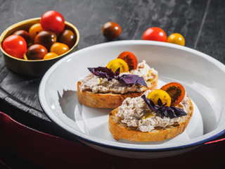 Tapas bruschetta with pate and basil in the enamel plate