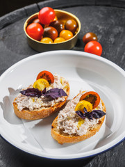 Tapas bruschetta with pate and basil in the enamel plate